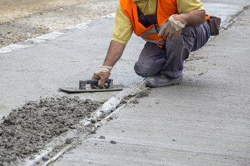 Mason leveling concrete with trowel
