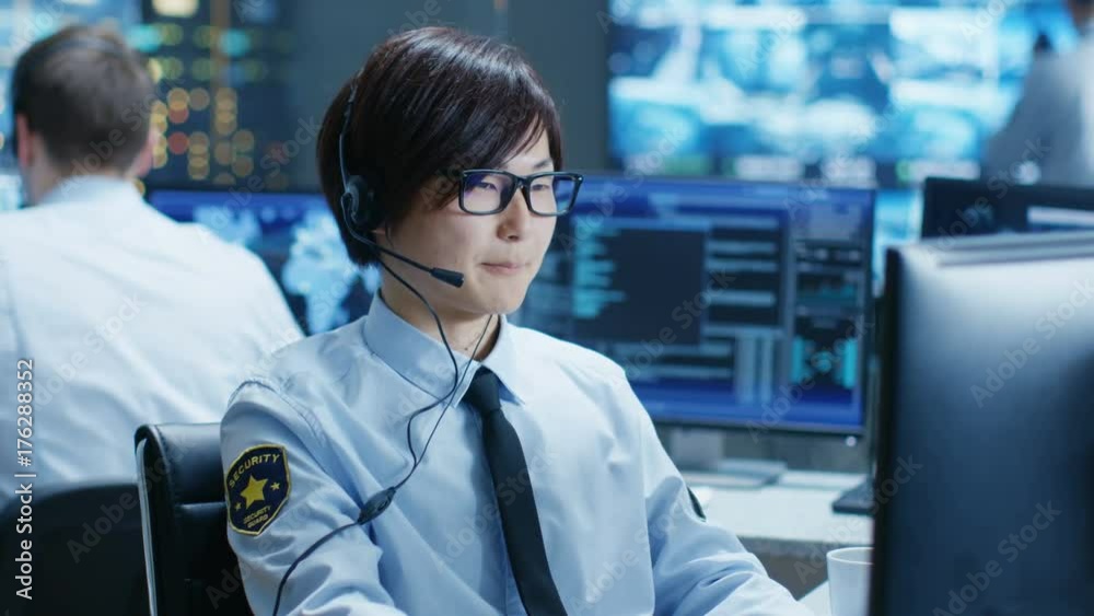 Poster In the Security Command Center Officer at His Workstation Monitors Screens and Communicates with Patrols through Headset. He is Part of the Surveillance Team. 