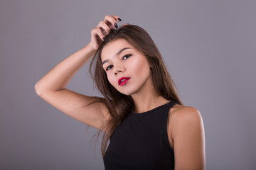 Obraz premium Brunette Woman with beauty makeup and red lips over gray background