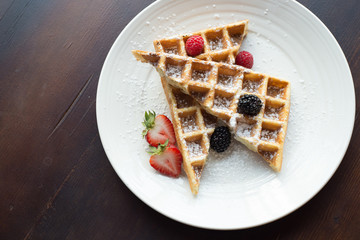 Waffles with Strawberries and Blackberries on wooden table