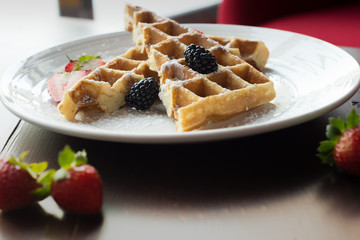 Waffles with Strawberries and Blackberries on wooden table