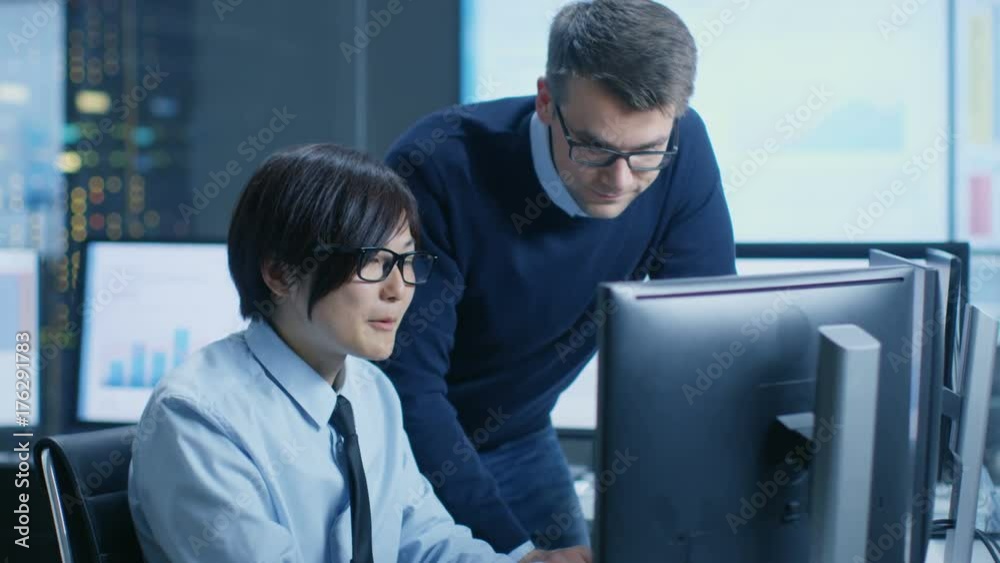 Poster in the data mining center chief statistician consults his young assistant sits at his workstation su