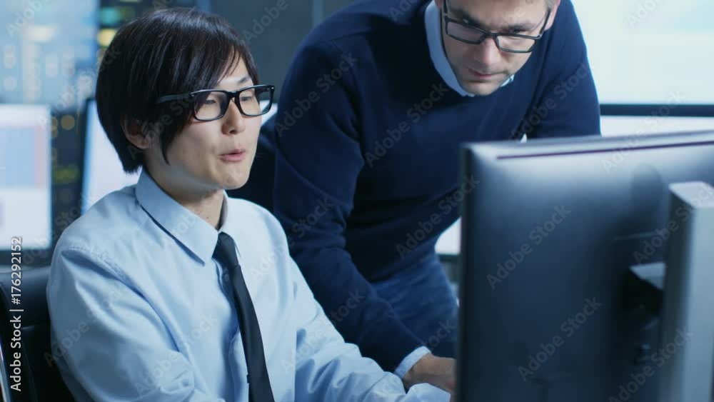 Aufkleber In the Data Mining Center Chief Statistician Consults His Young Assistant sits at His Workstation Surrounded with Monitors Displaying Data and Graphs. Shot on RED EPIC-W 8K Helium Cinema Camera.