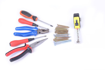 Screws in the box with screwdriver and pliers in the white