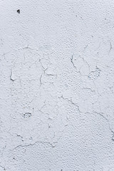 Detail of the old metal surface with with white cracked paint, closeup