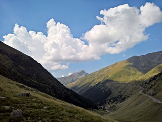 Obraz premium Dramatic white clouds over high mountains 