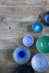 Ceramic bowls of different shapes and sizes on a wooden background. Copy space 