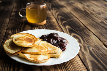 green tea and pancakes on wooden background