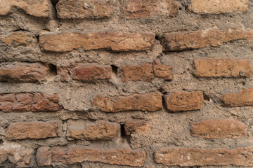 Old brick wall with cracks and scratches. Brick wall background. Distressed wall with broken bricks...