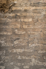 Old brick wall with cracks and scratches. Brick wall background. Distressed wall with broken bricks texture. House facade.