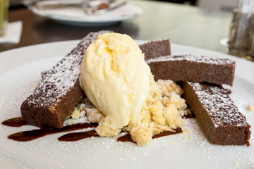 Chocolate brownie cake with a ball of vanilla ice-cream