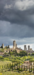 Fototapeta na wymiar vertical panorama with towers under clouds in Italy