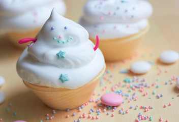  Christmas cupcakes with whipped cream in the form of a snowman. Sweets for children's holiday