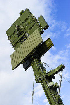 Air defense radar of military mobile antiaircraft system in green color, modern army industry, blue sky and white clouds on background 