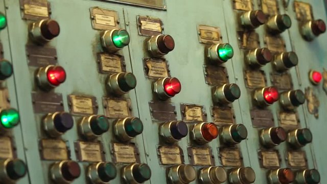Flashing red and green lights inside keys of old central pane of production machine tool during operation. Automatical processes on industrial plant.