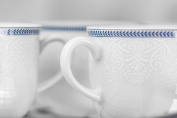 Set of clean white cups located on the shelf