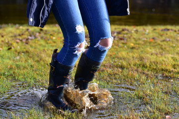 Fototapeta na wymiar Jumping in a puddle with wellies.