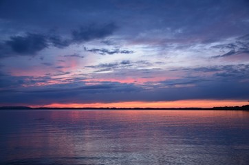 Imposante Abendstimmung bei Sonnenuntergang mit schwarzen Wolken am Chiemsee in den Alpen