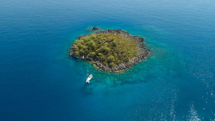 Sailing boat anchored to little island