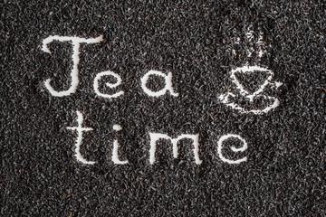 Inscription tea time with drawn cup or mug created on dried, loose tea. Enjoying of tea break at the work, at home, at visit with friends, family or alone everyday. Classic warm or hot drink. Top view