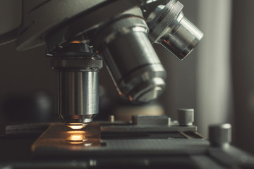 Close-up shot of microscope with metal lens at laboratory.