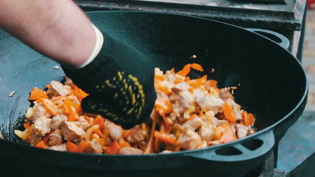 The most delicious Uzbek pilaf with carrots rice and meat is brewed in huge tub at the festival food court
