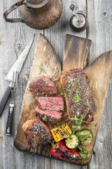 Two barbecue dry aged Kobe roast beef with vegetable as close-up on a cutting board