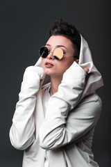 Portrait of a beautiful young girl wearing a white coat and sunglasses