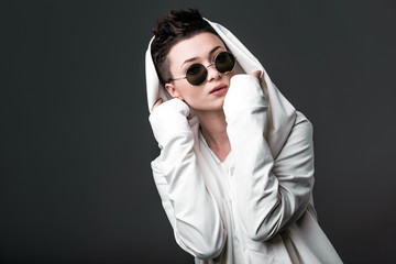 Portrait of a beautiful young girl wearing a white coat and sunglasses