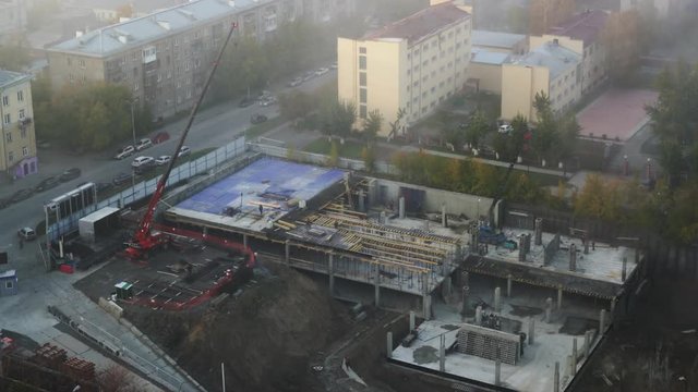 Workers builders with a crane build a building. Construction aerial view, time-lapse. Russia, Novosibirsk, Kirova/Sakko And Vancetti st., 2017-10-06