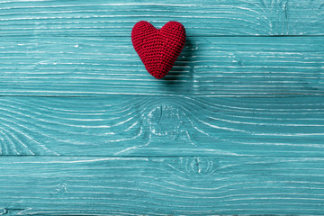 Knitted heart on a blue wooden background
