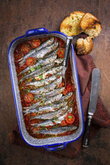 Sardinas en salsa with garlic bead as top view in a skillet