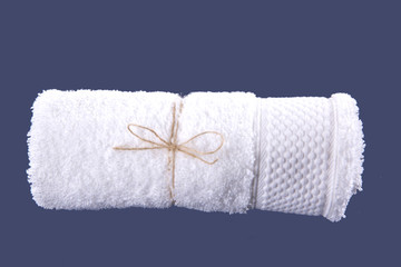 White towel rolled up on a blue background