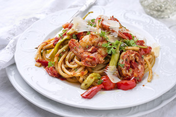 Italian linguine alla gamberetti with vegetable and parmesan as close-op n a plate
