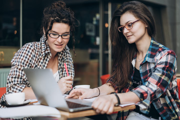 Clever students. Two girls are working with the laptop