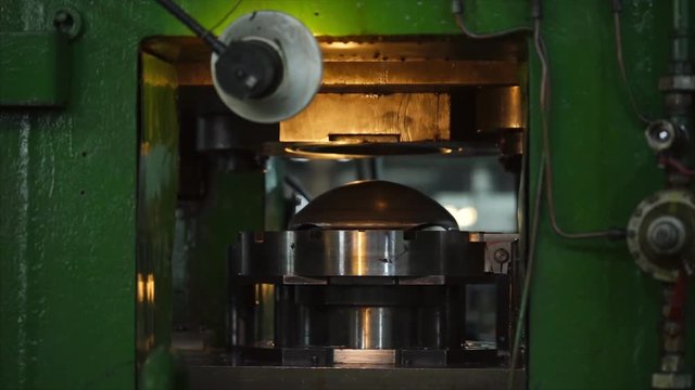 Special press machine forms details for the wheels. Workers put them in and take them out of there.