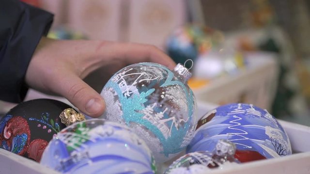 Close-up of New Year theme man's hand taking glass bowl with patten and slowly rotate it