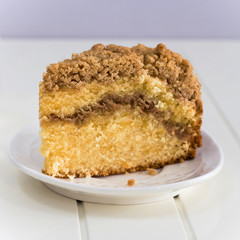 Homemade Cinnamon crumble coffee cake on white wooden background. Square photo.