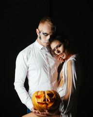 Halloween. Pumpkin. Fashion make up. Couple in love. Man white shirt. Halloween concept.