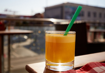 Glass of fresh orange juice at summer terrace cafe.