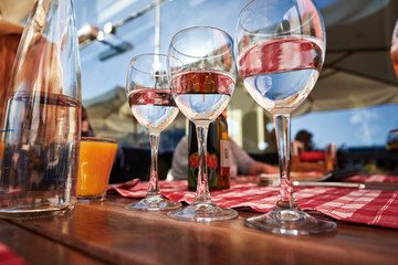 Row of pure drinking water glasses at summer terrace cafe.