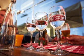 Row of pure drinking water glasses at summer terrace cafe.