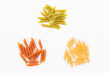 Handfuls of pasta in different colors on bright white background, colorful macaroni