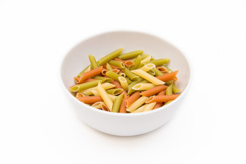 colorful pasta in white plate on bright white background, macaroni