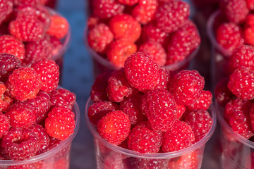 A lot of raspberries on the street market counter