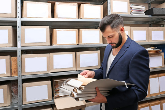 Man with documents in archive