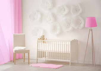 Interior of light cozy baby room with crib and bedding