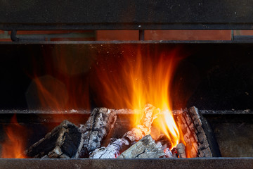 Burning firewood in the barbecue at backyard close up.