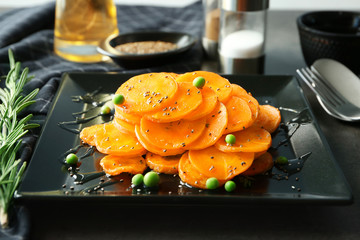 Plate with tasty carrot salad on table