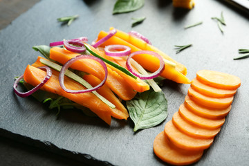Slate plate with tasty carrot salad on table